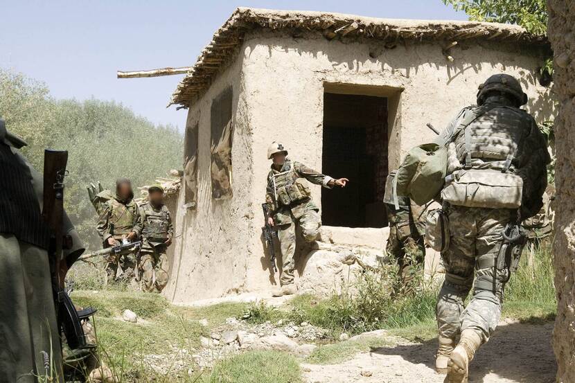 Gewapende militairen bij een vervallen huis in Chora.