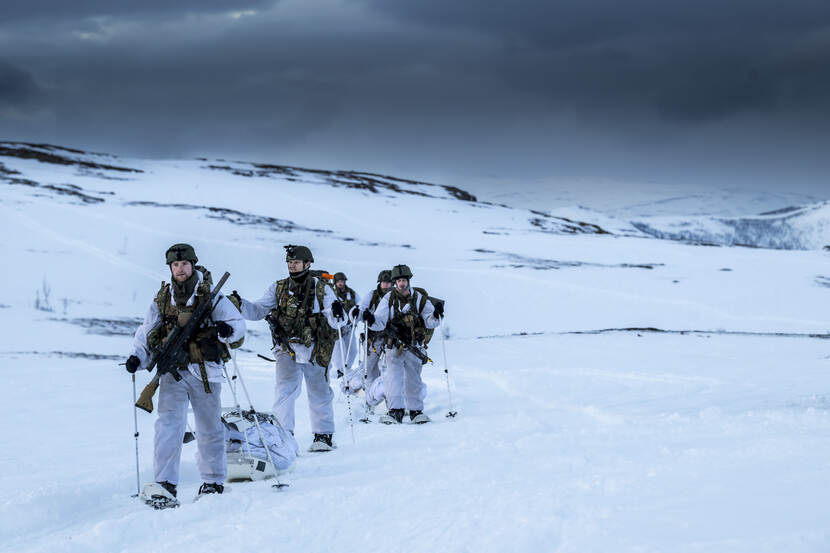 Mariniers lopen door een sneeuwlandschap.