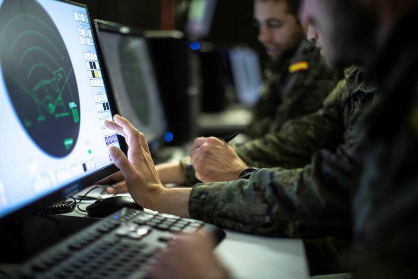 Militair achter groot computerscherm.