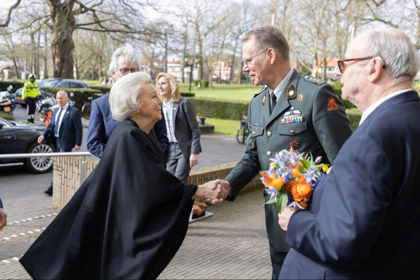 Prinses Beatrix schudt een hand.