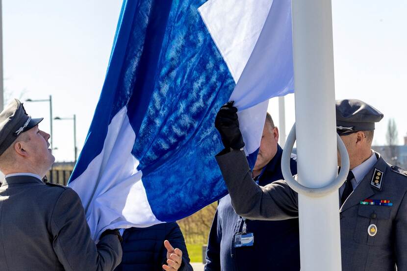 Militairen hijsen de Finse vlag.