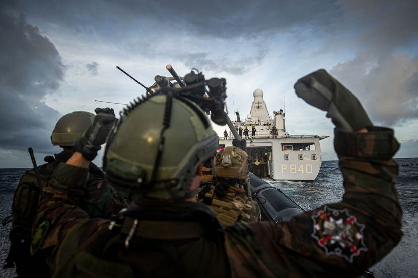 Mariniers in rubberboot met Zr.Ms. Holland op de achtergrond.