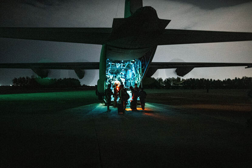 Militairen bij laadklep van een vliegtuig.