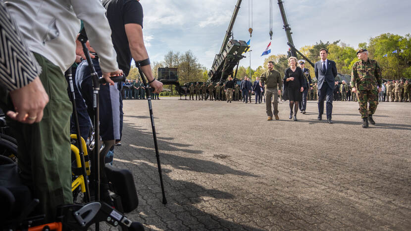 Hoogwaardigheidsbekleders lopen richting gewonde Oekraïense militairen.
