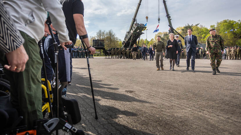 Hoogwaardigheidsbekleders lopen richting gewonde Oekraïense militairen.