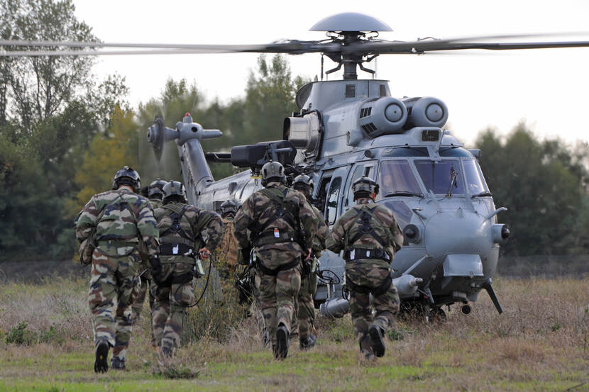 Troepen lopen naar helikopter om in te stijgen.