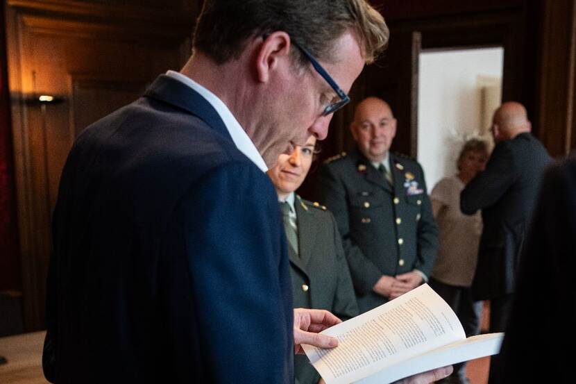 Staatssecretaris Christophe van der Maat bekijkt het boek.