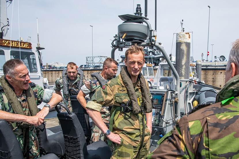 Een groepje militairen aan het praten in de sleepboot Schelde.