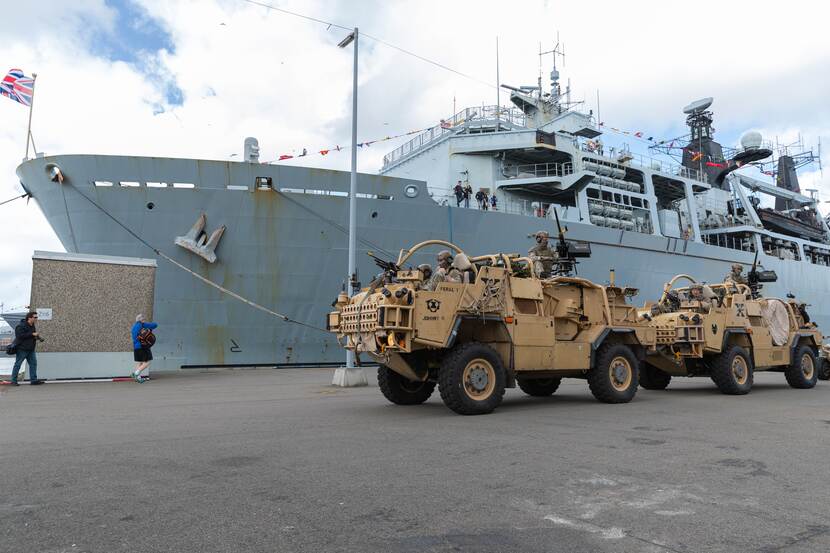 2 Britse militaire voertuigen rijden voor het amfibisch transportschip HMS Albion.