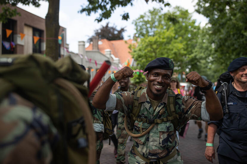 Meelopende militair steekt vuisten in de lucht.