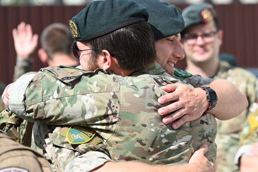 2 militairen omhelzen elkaar.