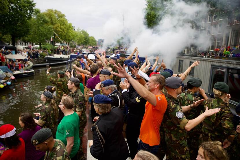 Mensen dansen op een boot die door een gracht vaart.