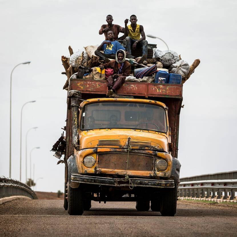 Oude vrachtauto volgepakt met mensen en afval in Mali.