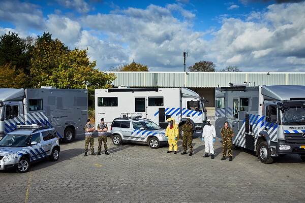 Politiebureau in Eindhoven met ervoor voertuigen en militair personeel.