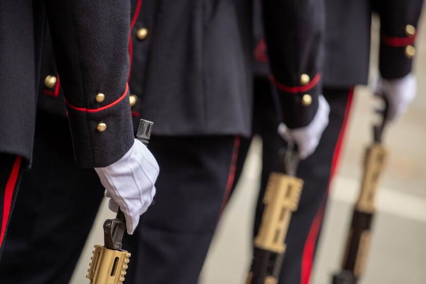 Detailfoto ceremonieel,  handen in witte handschoenen houden wapen vast.