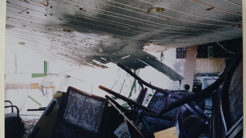 Eetzaal met hoop oud meubilair en ingestort plafond in voormalig Joegoslavië.