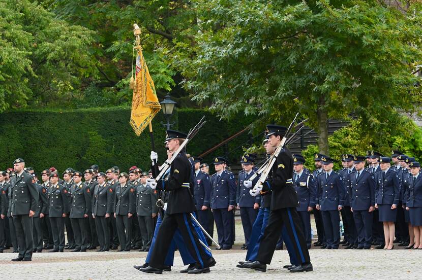 Vaandelwacht treedt aan. Daarachter aangetreden militairen.