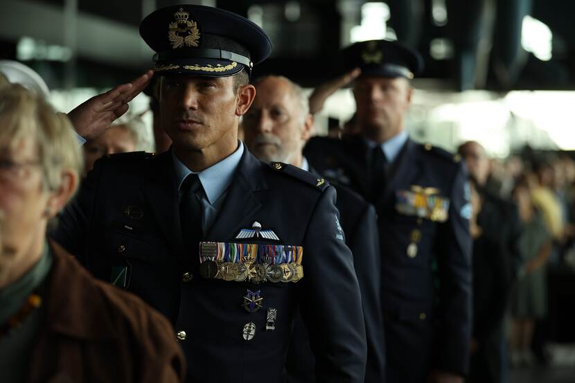 Militairen brengen groet. Op voorgrond militair met veel medailles op zijn uniform..