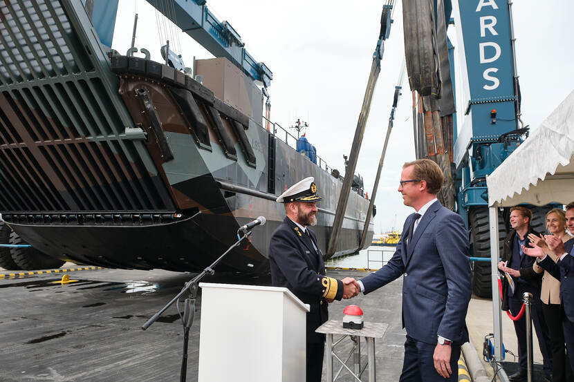 Staatssecretaris Christophe van der Maat schudt de hand van marineofficier.