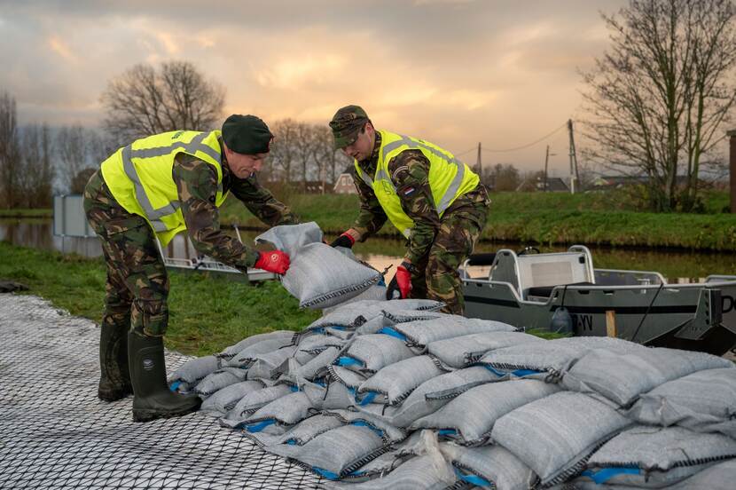 De militairen leggen zandzakken.