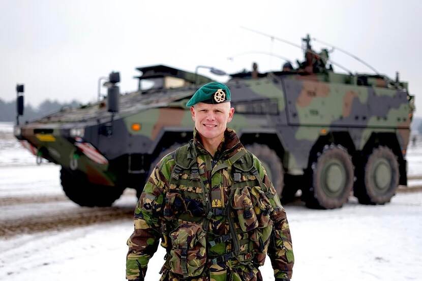 Generaal-majoor Jan Swillens met op de achtergrond een legervoertuig.