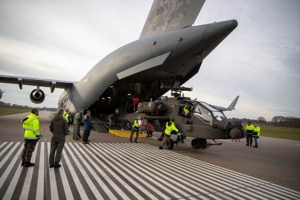 Een gevechtshelikopters wordt uit een C-17-transportvliegtuig gereden.