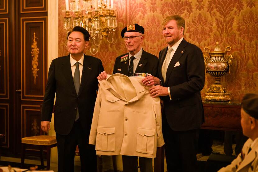 President Yoon reikt een militair uniform uit aan Nederlandse veteranen.