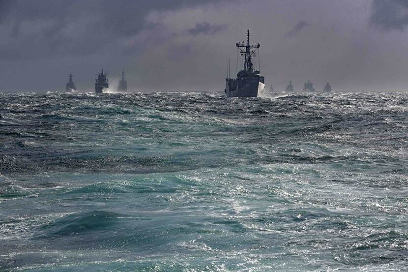 Marineschepen op een ruwe zee.