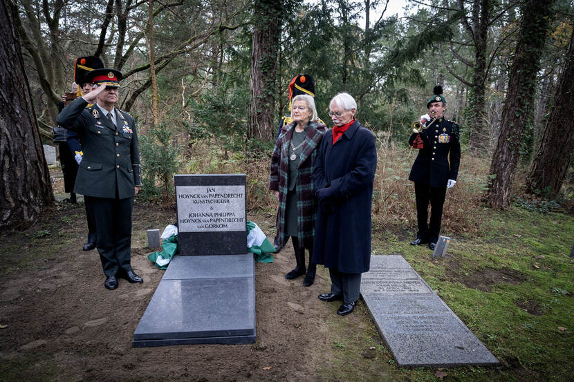Militair historicus en biograaf Jacques Bartels (met rode sjaal) en burgemeester van Bloemendaal Ankie Broekers-Knol bij het graf.