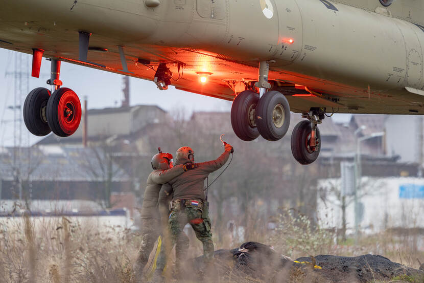 Militairen proberen net aan te haken onder Chinook-transporthelikopter.