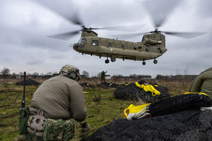 Netten met zware stenen liggen klaar om door een Chinook te worden opgetild.