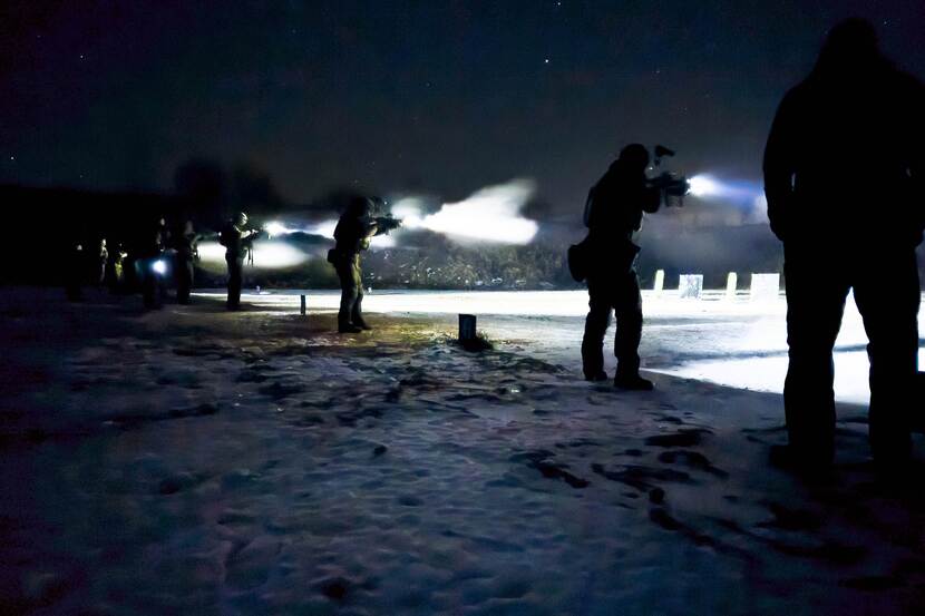 Militairen schieten met nachtzichtapparatuur.