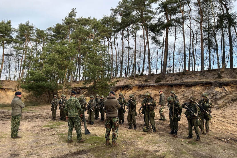 Groep specialisten bijeen in bosrijk gebied.