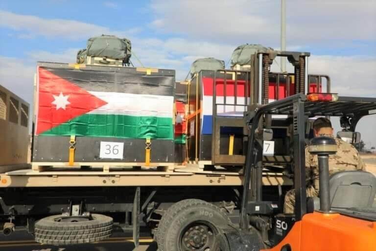 Heftruck lost pallets met goederen, om ze naar de C-130 te brengen. Op de goederen de Jordaanse en Nederlandse vlag.