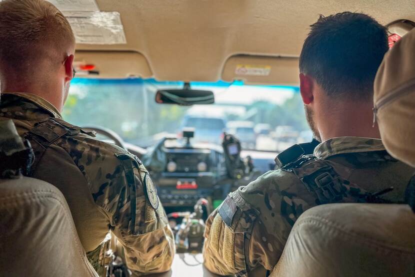 2 militairen achter het stuur van een voertuig in Bagdad.