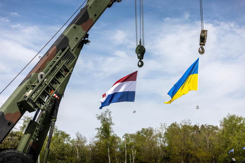 Nederlandse en Oekraïense vlag wapperen aan een hijskraan.