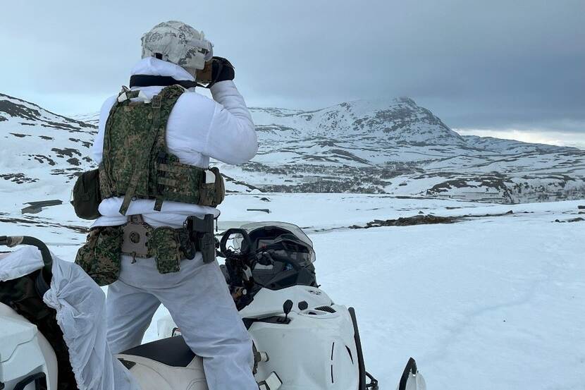 Een marinier van het 21e Raiding Squadron van 2nd Marine Combat Group scant met een verrekijker de omgeving.