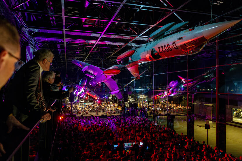 Toeschouwers voor een podium op de Nacht van de Militaire Muziek.