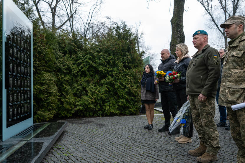 De minister legt bloemen bij een monument in Oekraine.