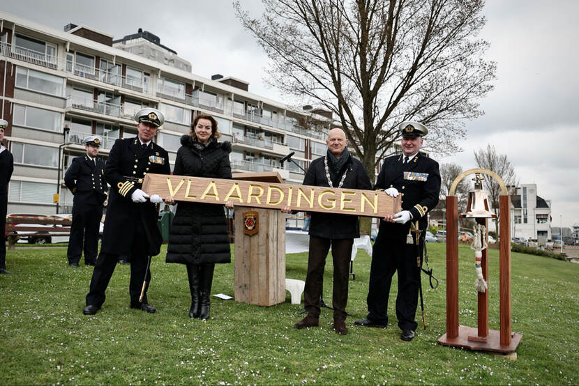 Bemanningsleden overhandigen het naambord aan de burgemeester en wethouder van de gemeente Vlaardingen.