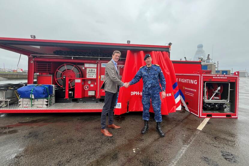 De pompen met daarvoor iemand van het NIPV en een militair van de marine die elkaar een hand geven.