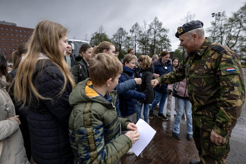 Commandant der Strijdkrachten generaal Onno Eichelsheim geeft kinderen van een basisschool een boks.
