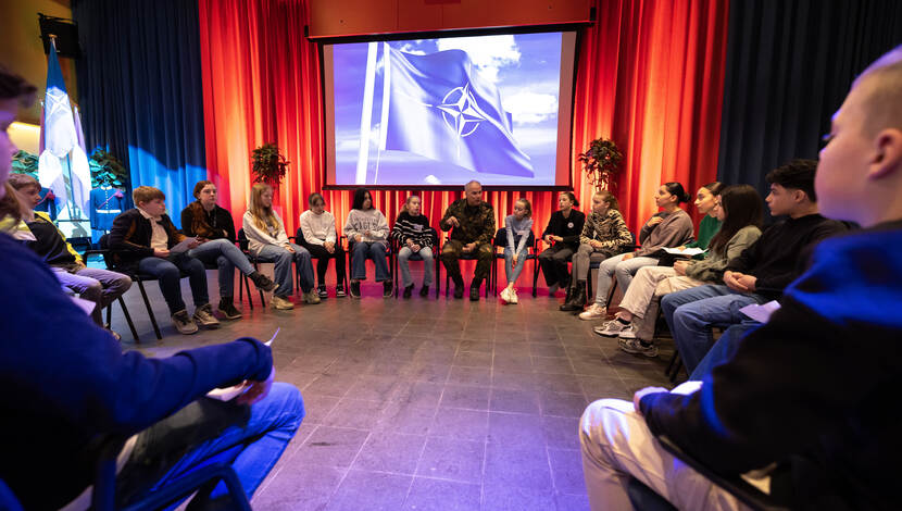 Commandant der Strijdkrachten generaal Onno Eichelsheim zit in een kring met kinderen van een Rotterdamse schoolklas.