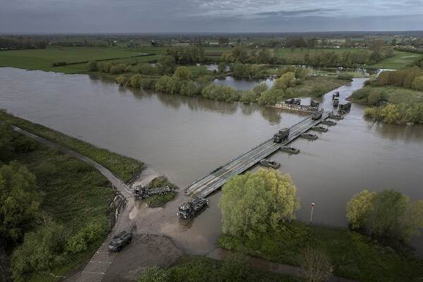 Militairen van de landmacht leggen een potonbrug aan over de IJssel