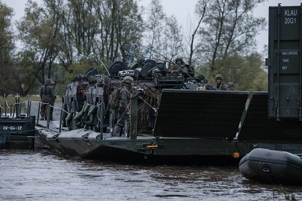 Militairen van de landmacht leggen een pontonbrug aan over de IJssel.