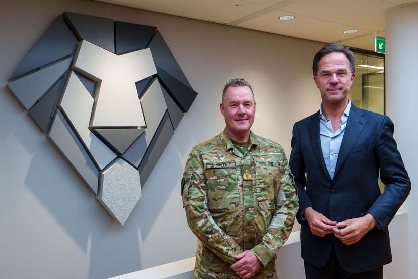 Premier Mark Rutte met links militair.