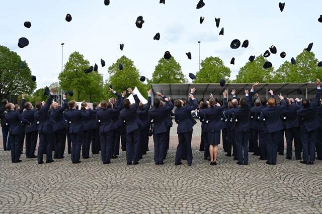 Officieren gooien hun pet of baret in de lucht.