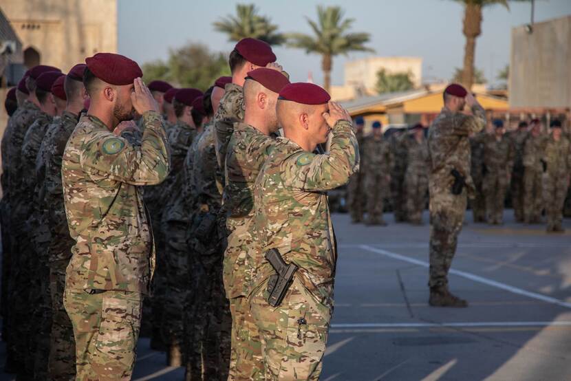 Militairen van de Luchtmobiele Brigade op missie in Irak brengen eregroet.