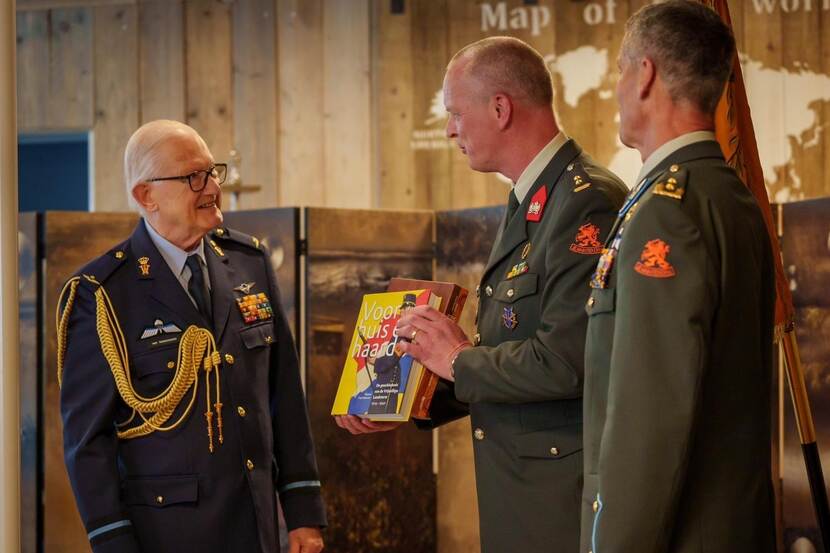 Prof. mr. Pieter van Vollenhoven krijgt een boek uit handen van korpscommandant Nationale Reserve luitenant-kolonel Hans Berding.
