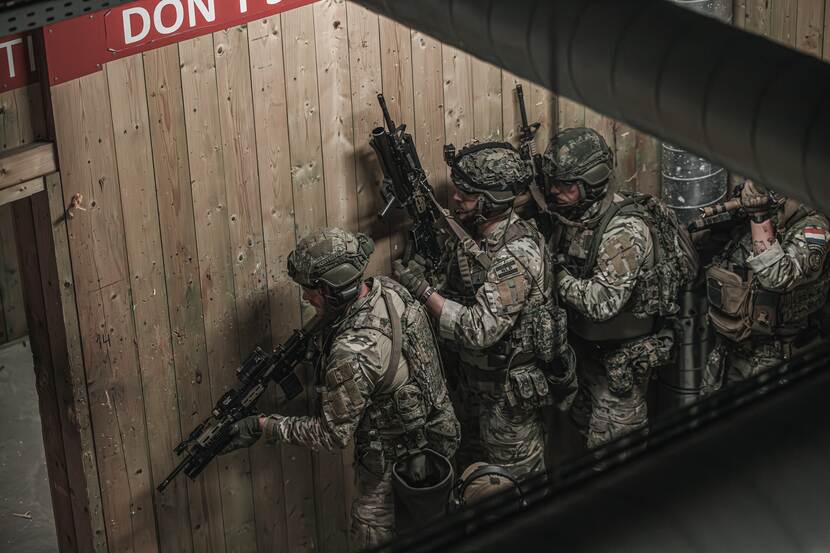 Rij bewapende militairen paraat om aan te vallen.